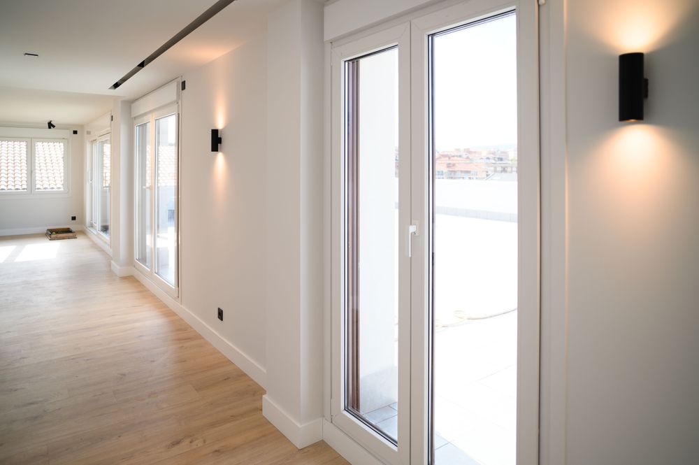 Open-plan living space of the home in Jaureguialde with glass doors to the terrace and wood flooring