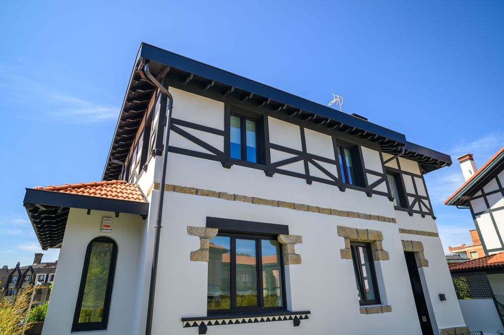 Detail of the Arriluce mansion facade with stone window surrounds and restored dark half-timbering