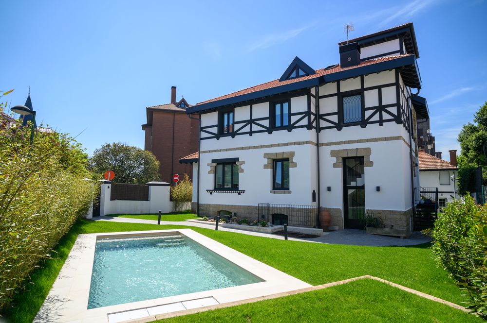 The Arriluce mansion after renovation, with the landscaped garden and the new pool in the foreground