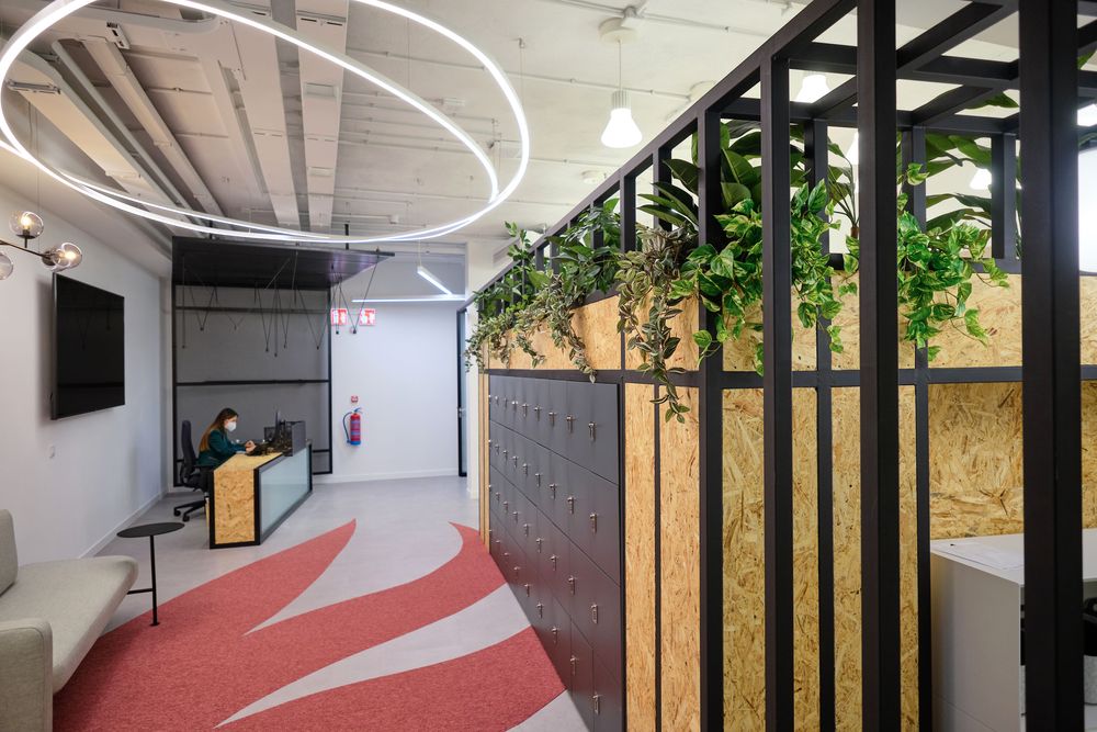 Corridor of the Smartgrid Innovation Hub with black lockers, OSB panels, and plants on the metal lattice
